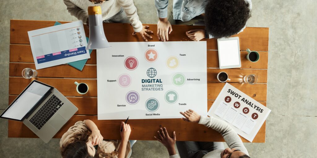 mesa de trabajo con equipo viendo estrategia de marketing digital